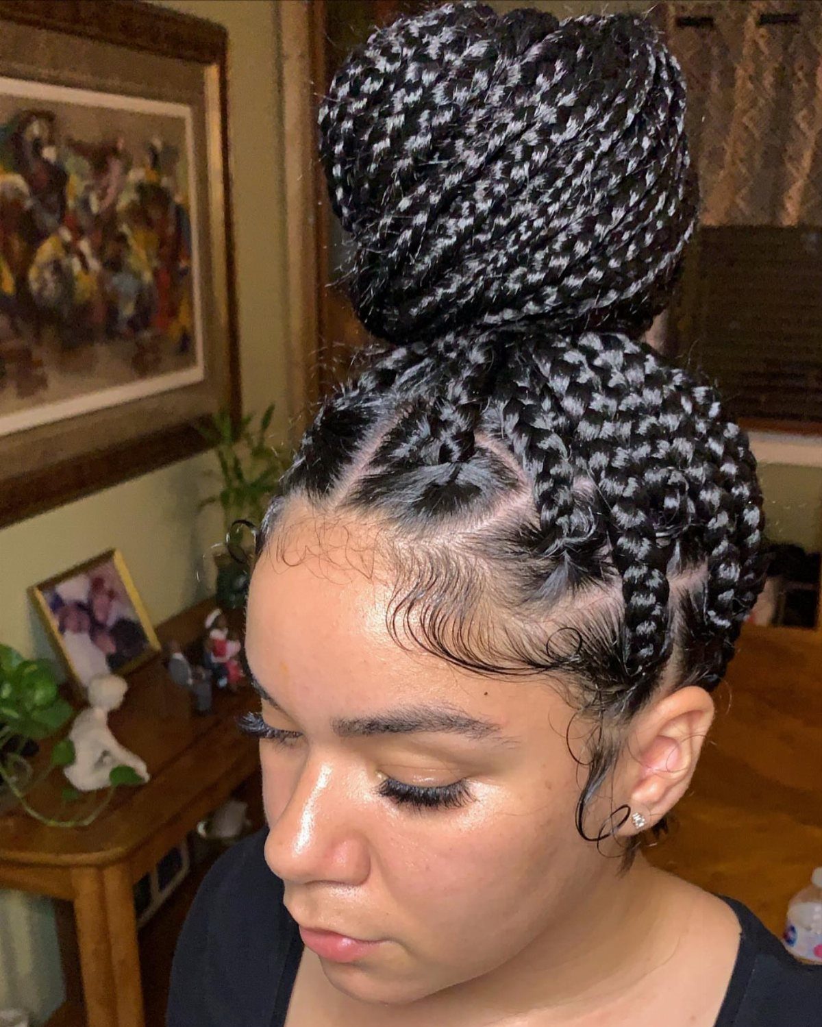 Woman wearing a large braided high bun with neatly styled edges