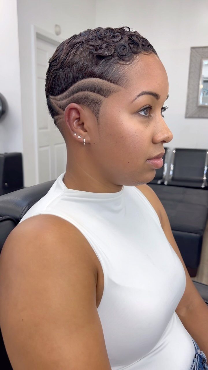Woman with short curly hair and curved shaved lines at a salon
