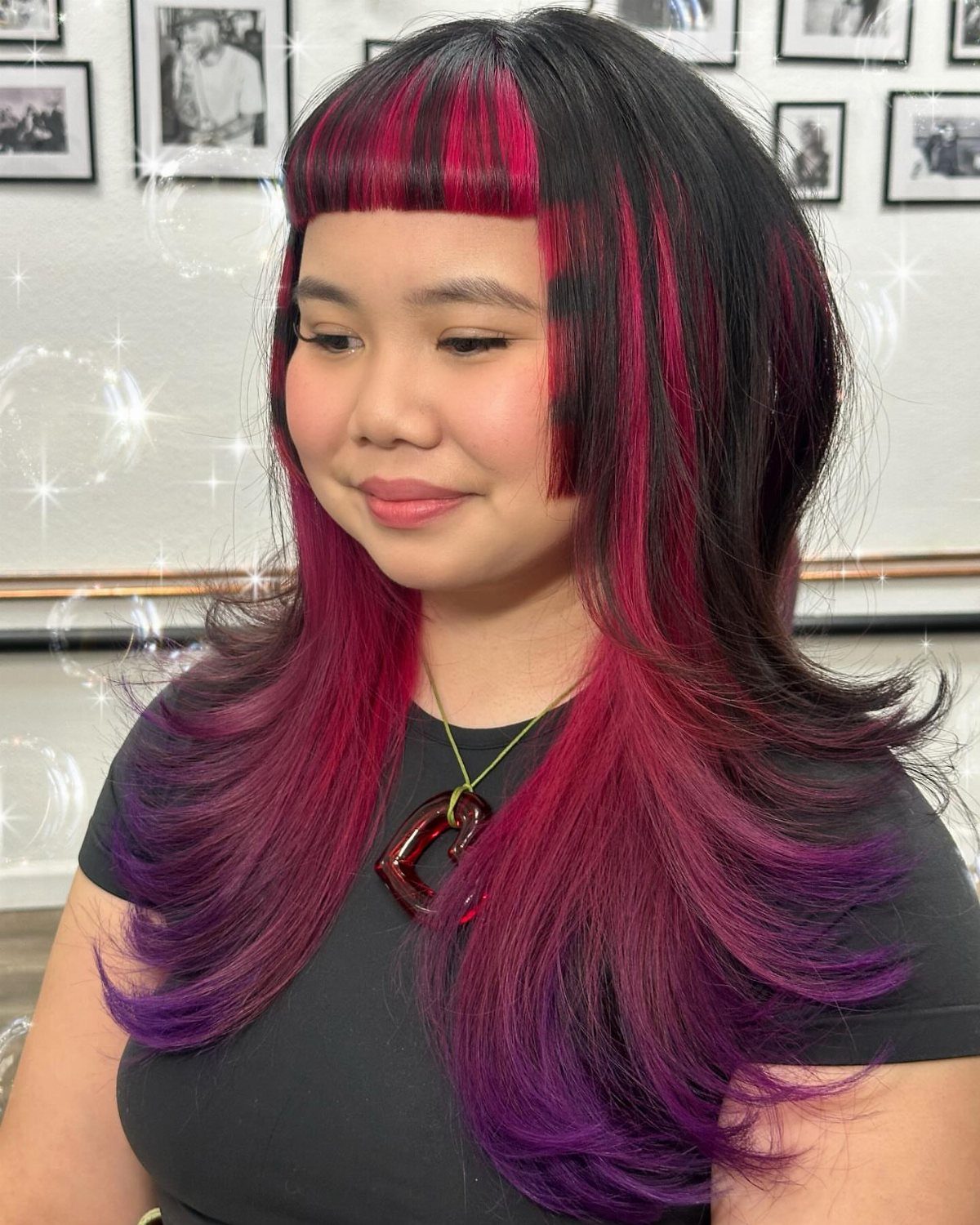 Woman with long layered magenta and purple hair and short straight bangs in salon
