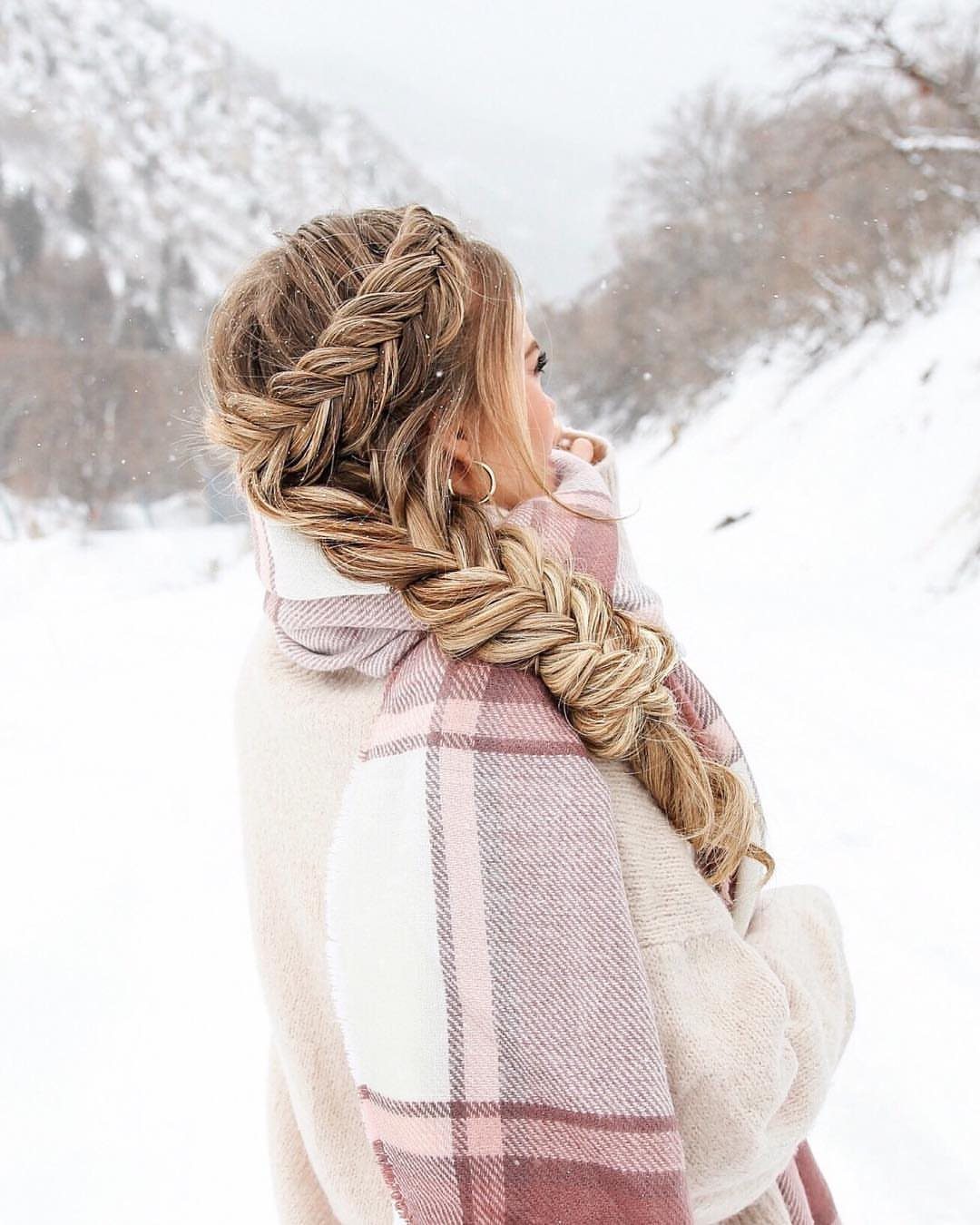 Blonde hair styled in a front twist flowing into a thick side braid