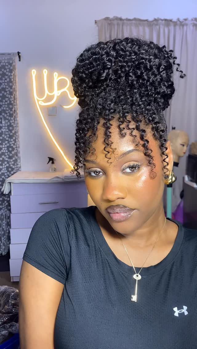 Woman showing a curly bun with loose ringlets framing her forehead
