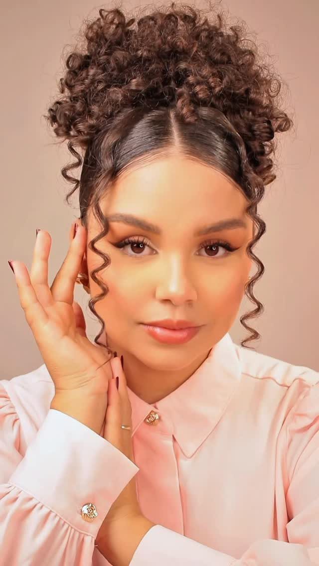Woman with voluminous curly hair gathered in a high updo