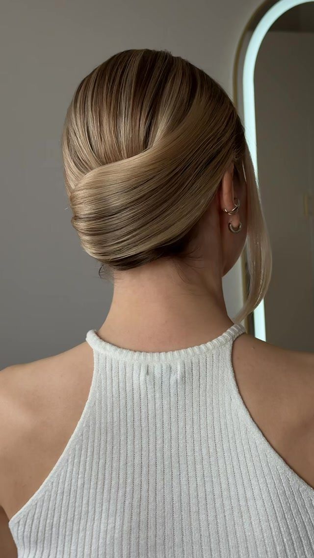 Brunette hair arranged in a smooth French twist at the back of a woman's head