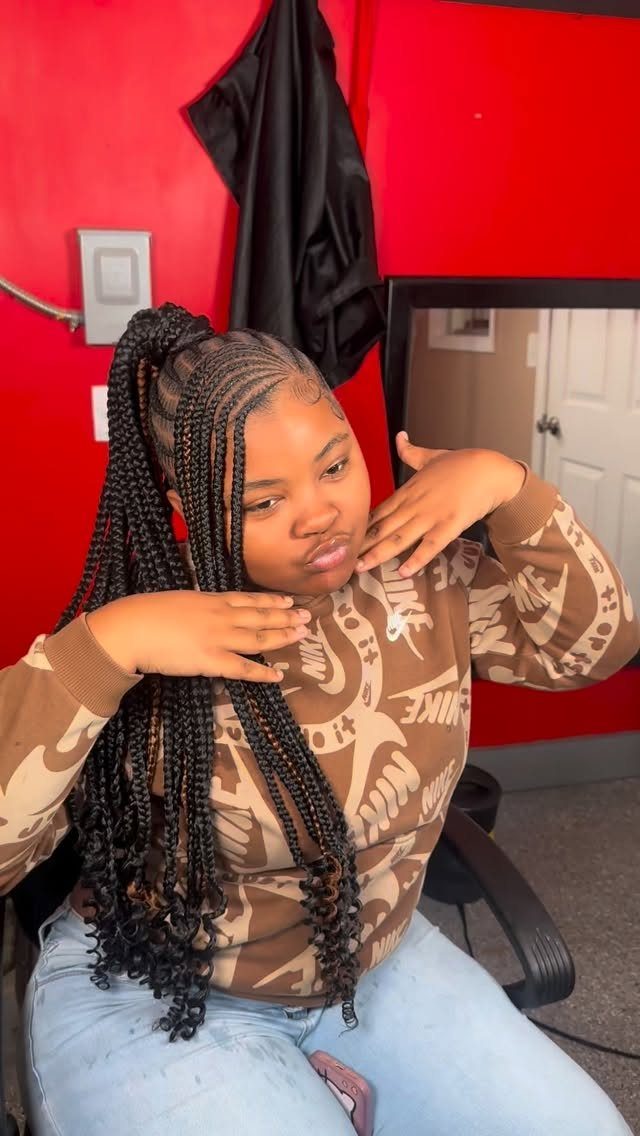 Woman posing with a high ponytail of long, tightly woven braids