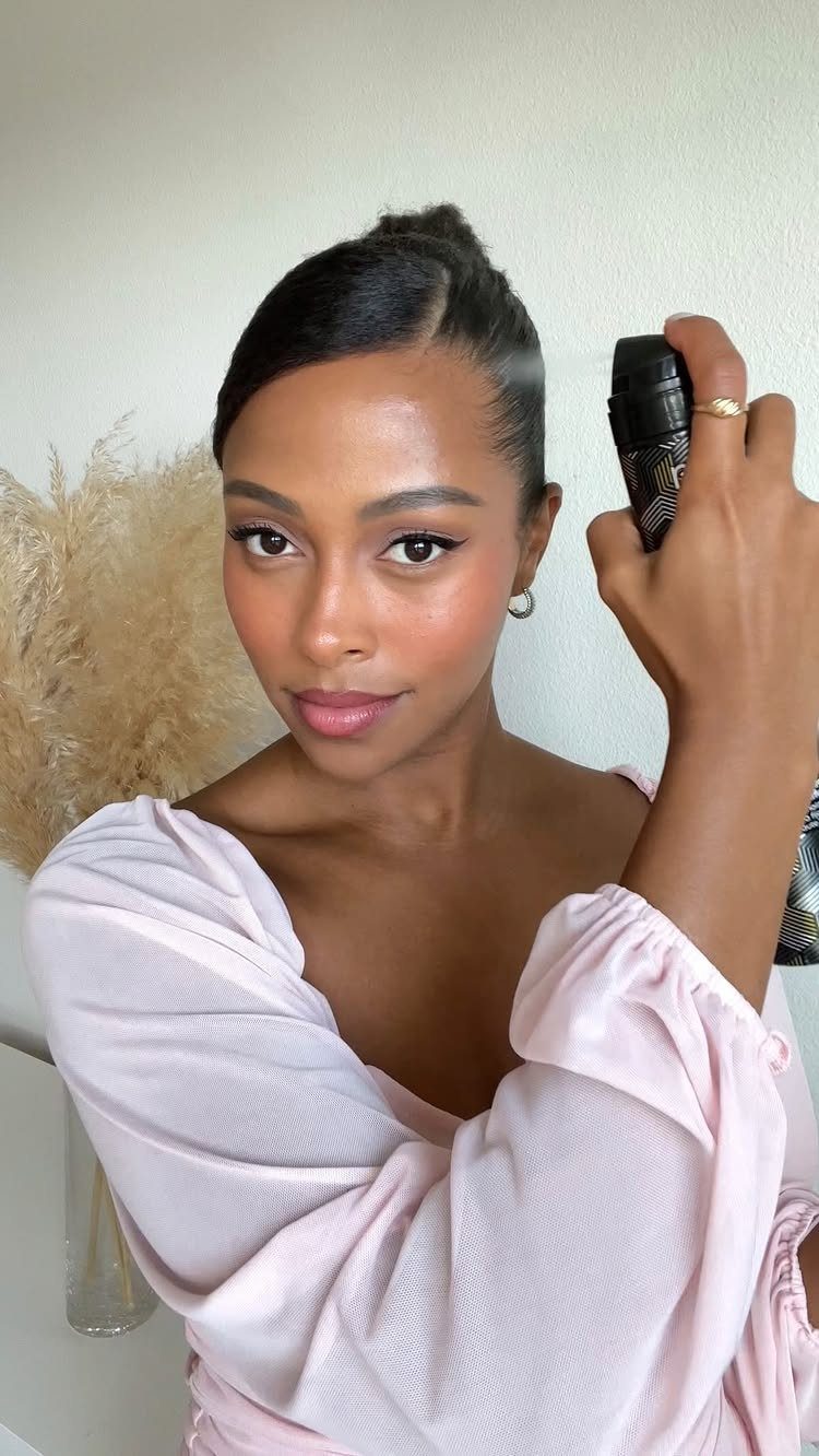 Woman styling sleek side-parted hair with a spray bottle