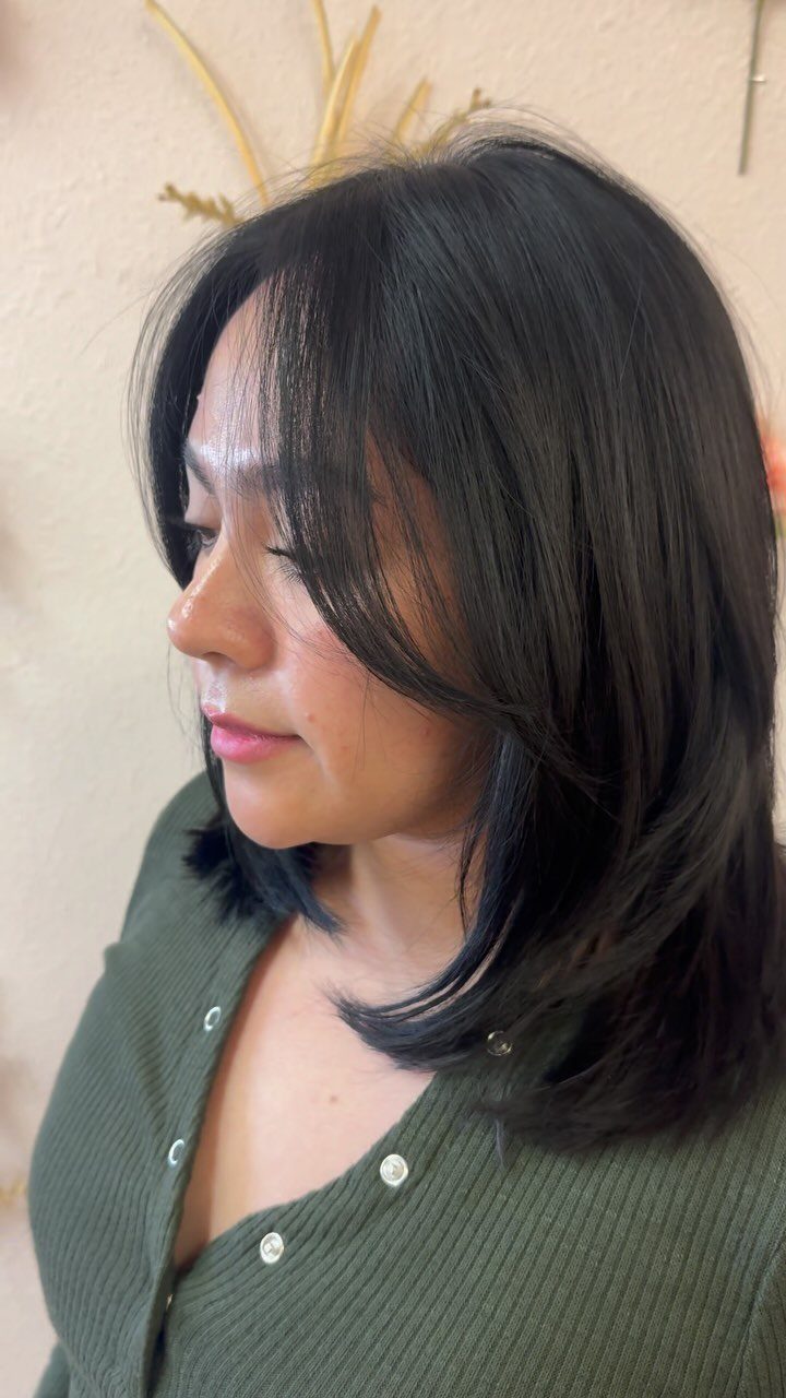 Woman with dark layered hair reaching her shoulders, viewed in profile