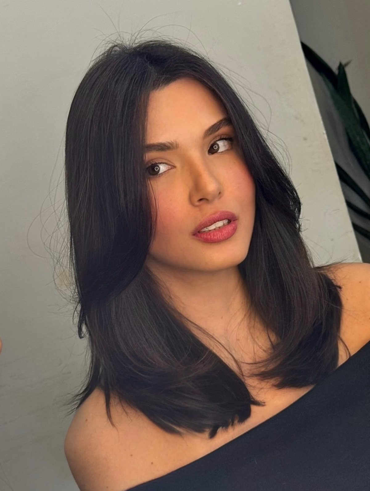 Woman with dark shoulder-length layers framing her face