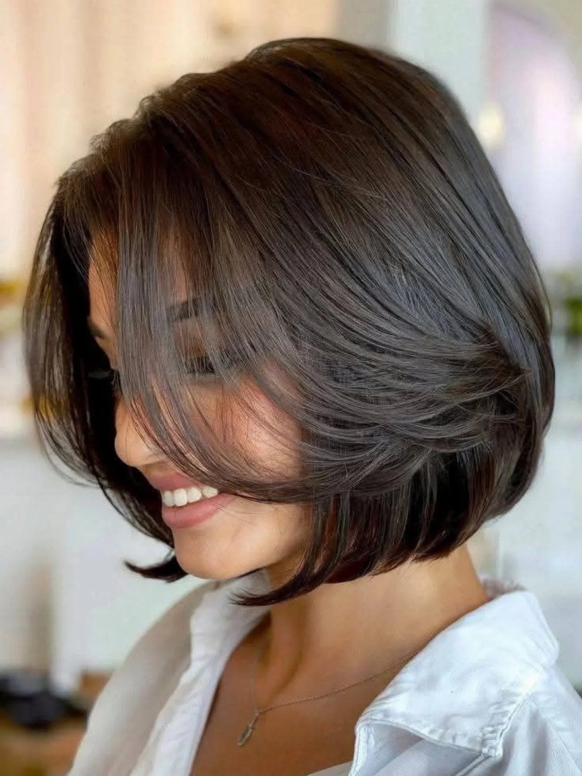 Full dark brown neck-grazing bob with curved ends and sweeping layers