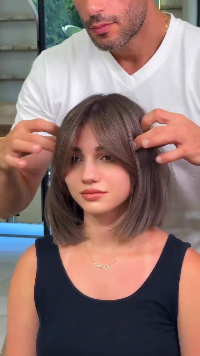 Woman with a brown bob and swoopy curtain bangs in a salon