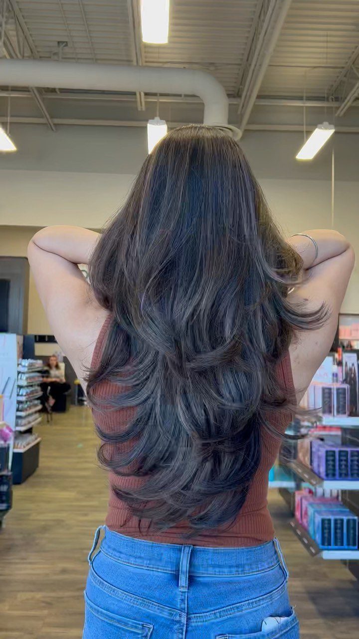 Long dark hair with layered ends tapering to a point at the back