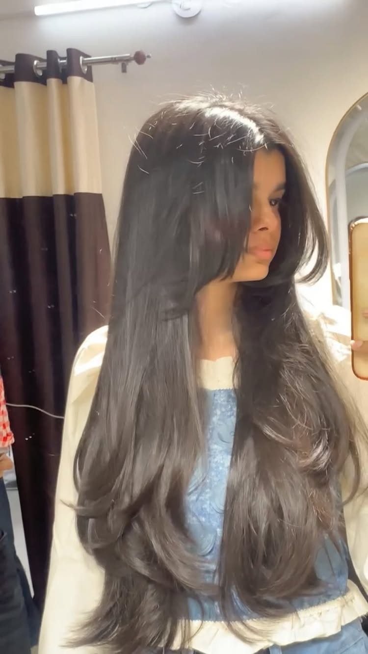 Long dark hair with face-framing layers and feathered ends