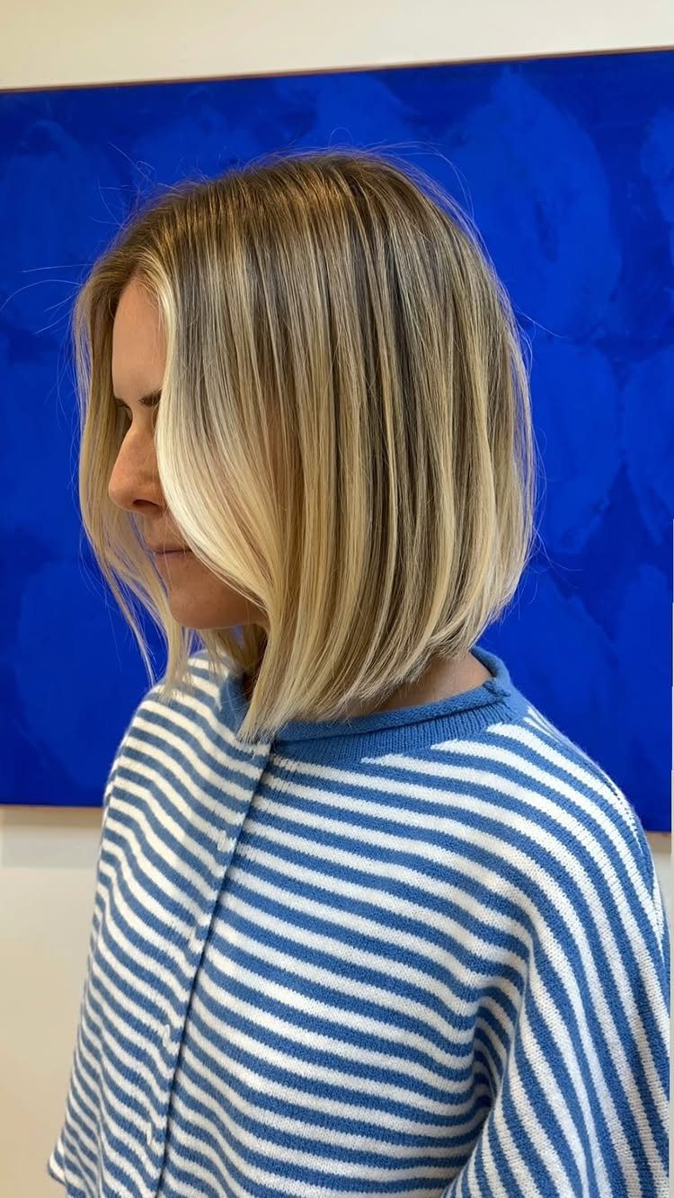 Blonde blunt bob with dark roots and a smooth, sharply defined perimeter