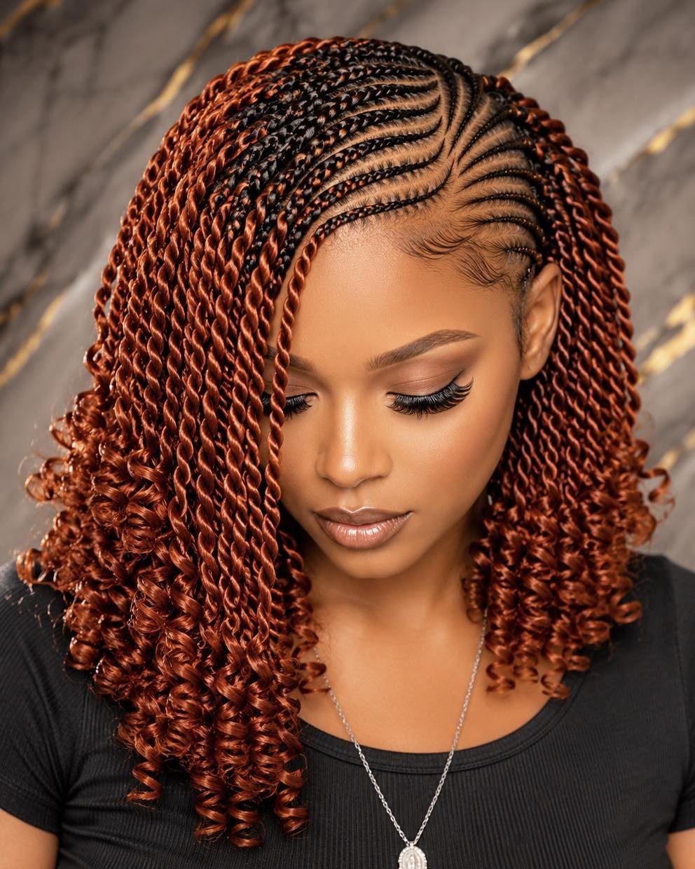 Woman with long copper-brown braids and curled ends, wearing a black top