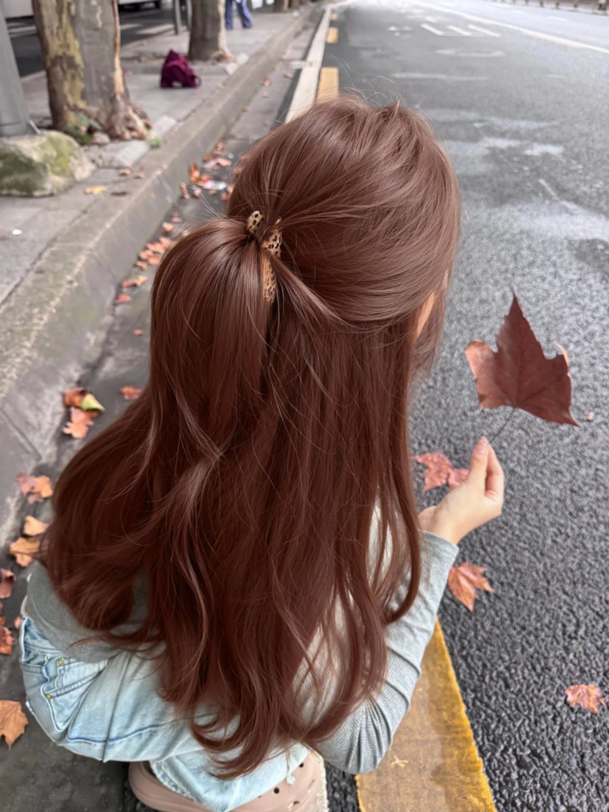 Long reddish auburn hair falls in loose waves, partly pinned back with a clip