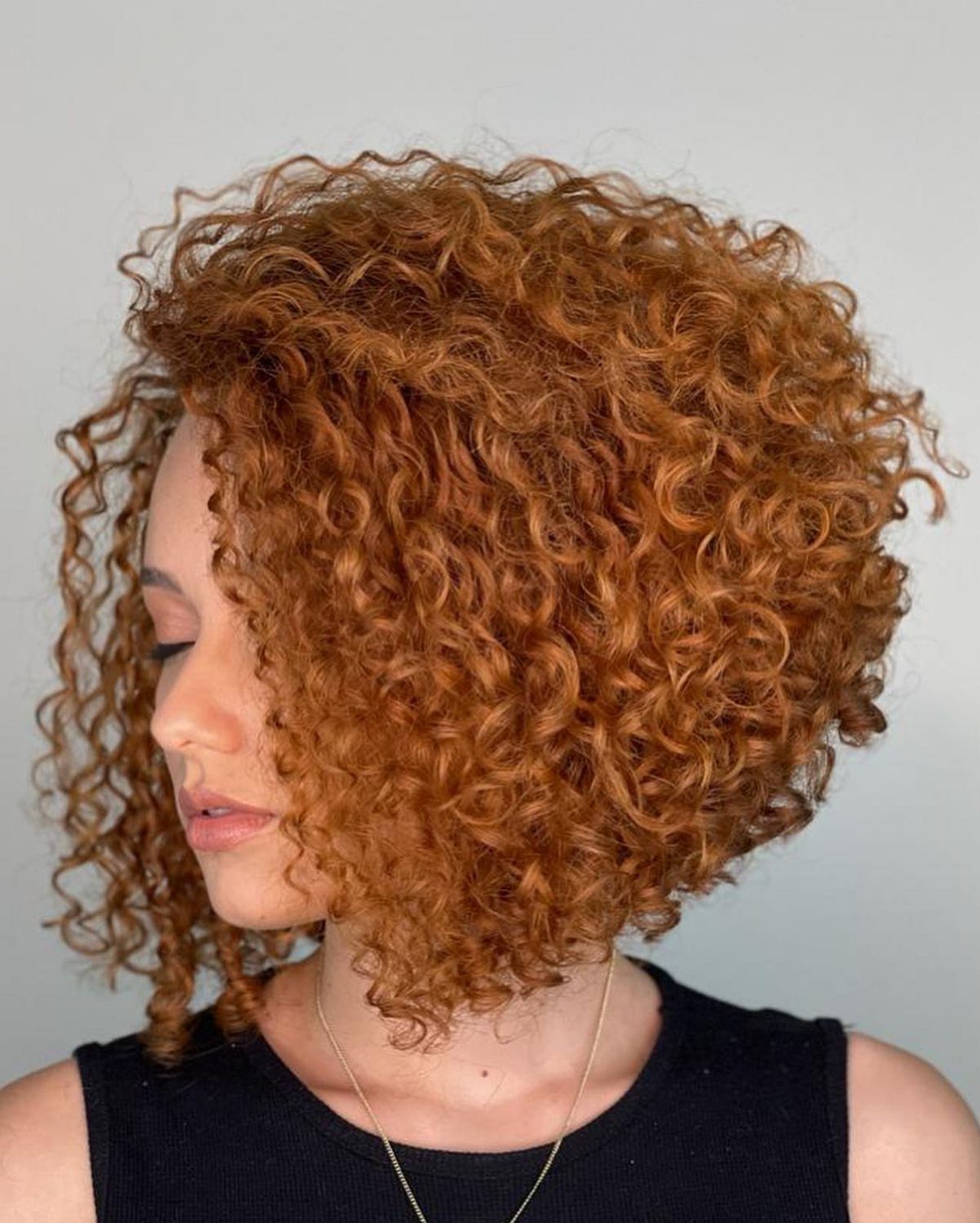 Auburn curls shaped into a rounded, tapered chin-length bob