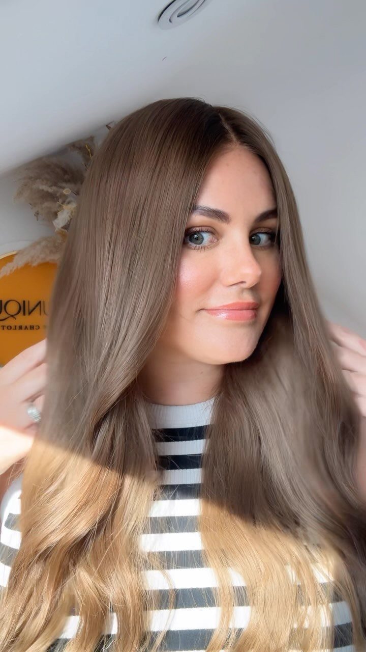 Woman posing with long straight brown hair fading into golden blonde ends