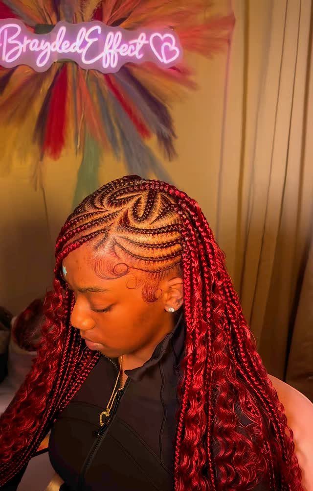 Person with intricate black-and-red braids and long curly extensions