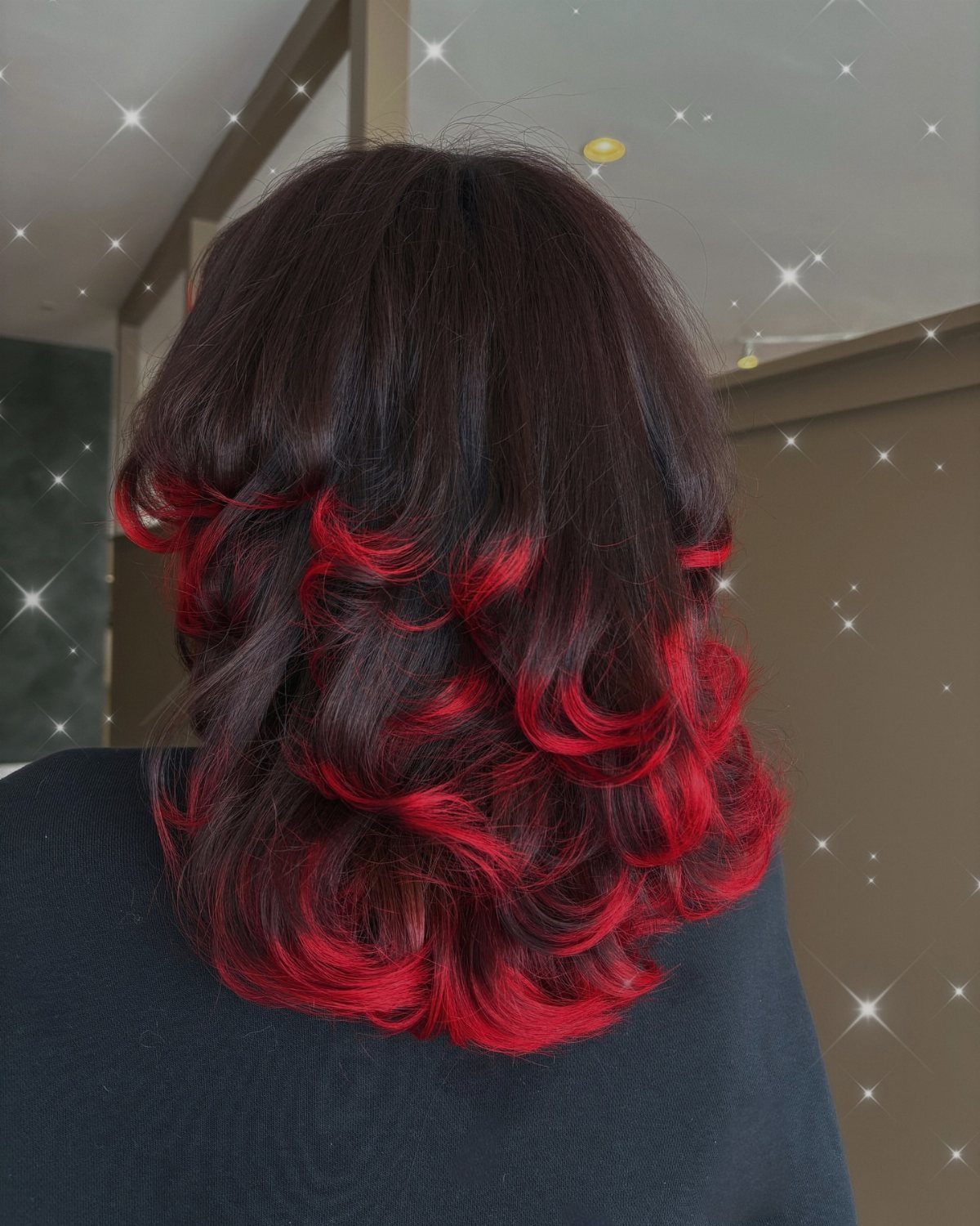 Layered dark hair with vivid red curled ends viewed from behind