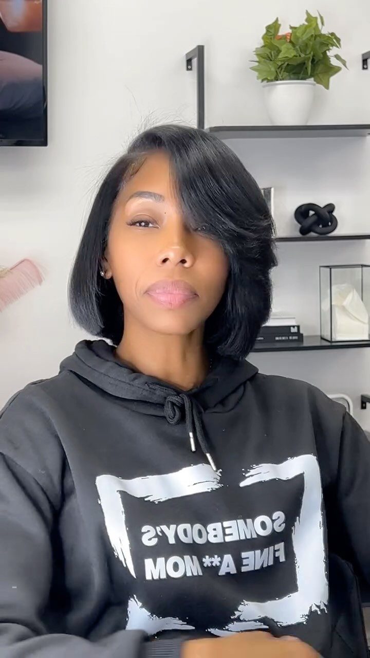 Woman models a sleek black angled bob with longer front layers