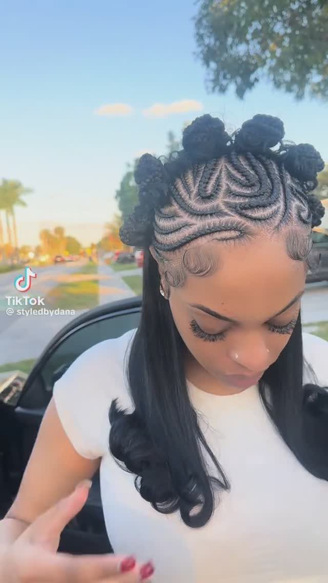 Young woman displaying curved cornrows gathered into Bantu knots with long curls