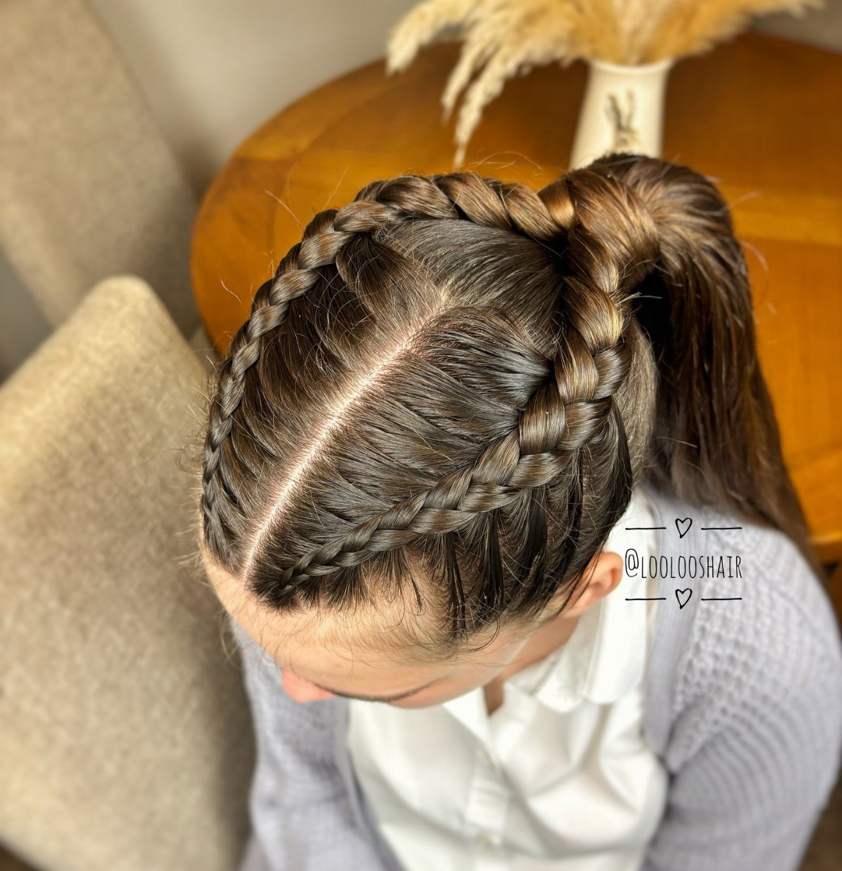 Double Dutch braids join into a high ponytail on dark brown hair