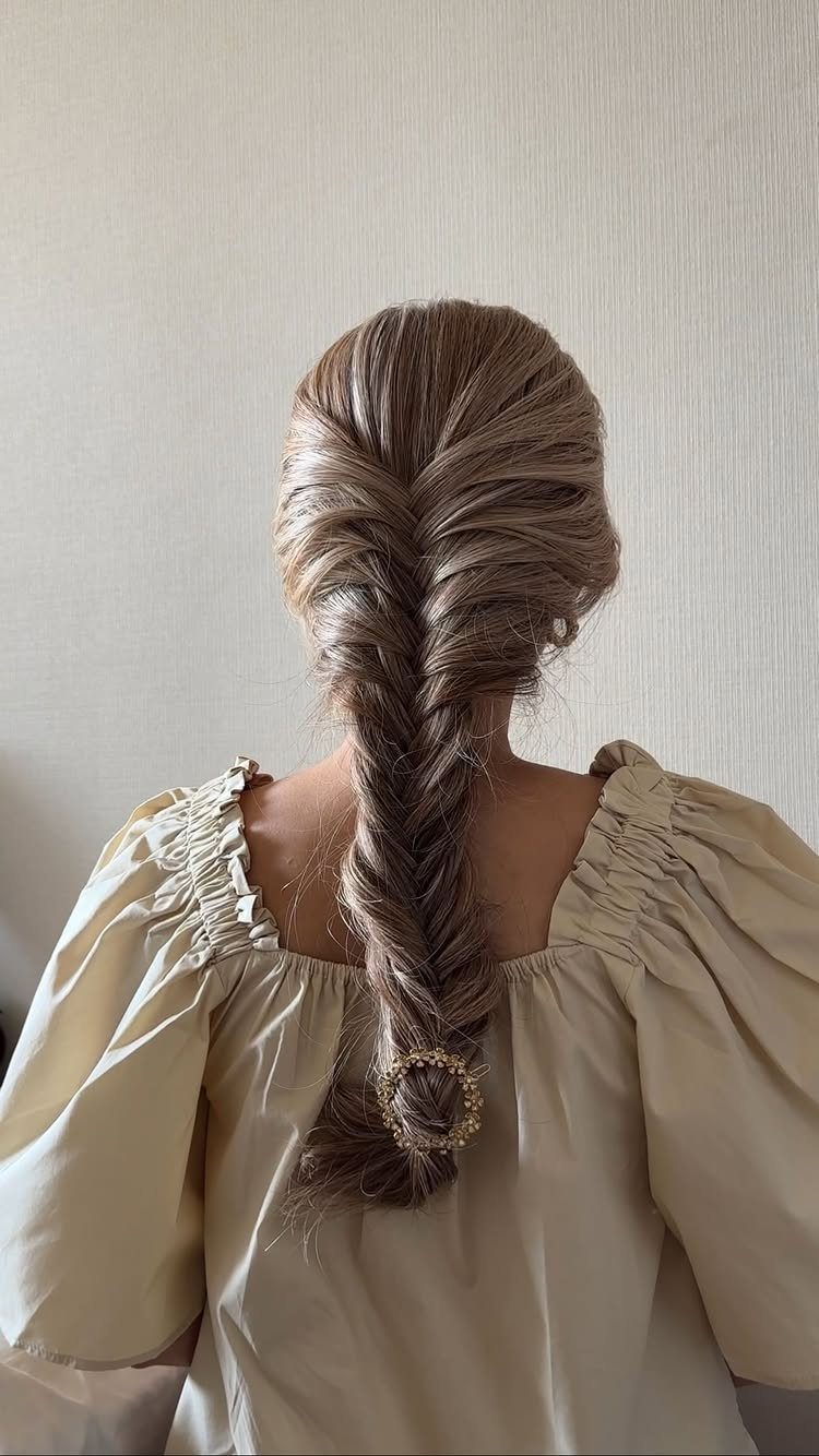 Long brown hair styled into a thick textured braid down the back