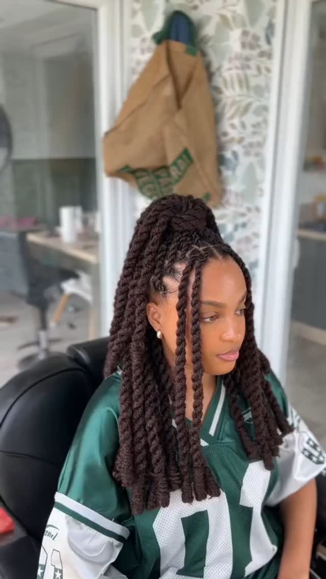 Young woman wearing long twists in a high half-up style with loose lengths