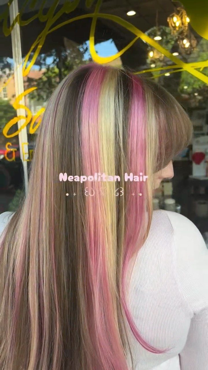 Long straight hair with wide pink and pale blonde highlights in a salon