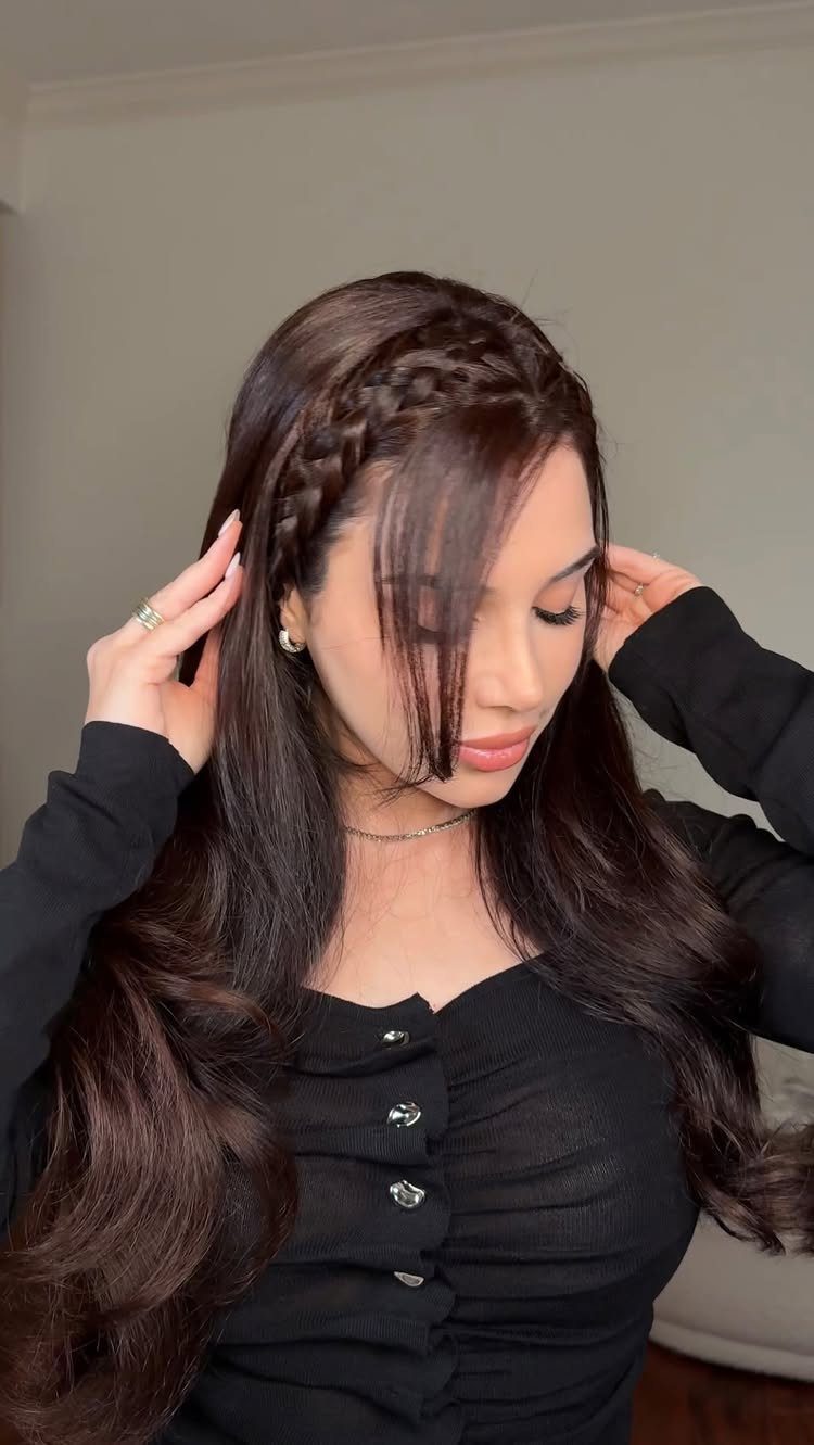 Young woman wearing a thin side braid with loose face-framing bangs