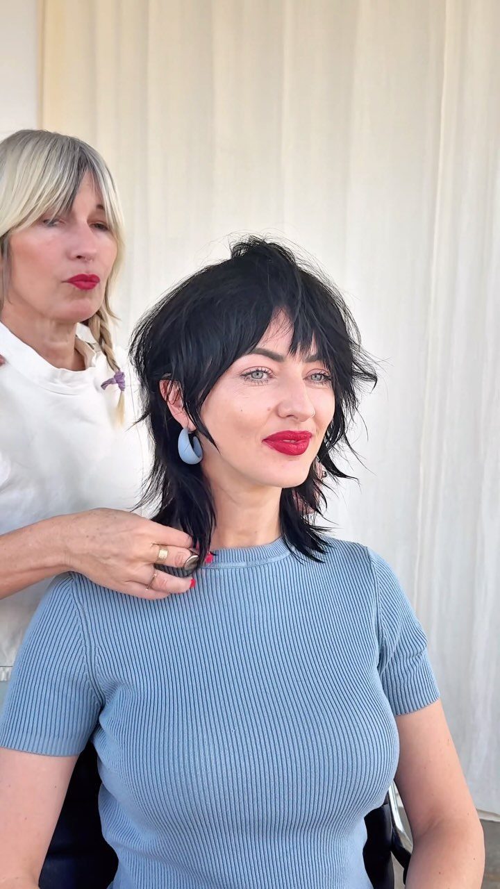 Hairstylist arranges a woman's short, layered black crop