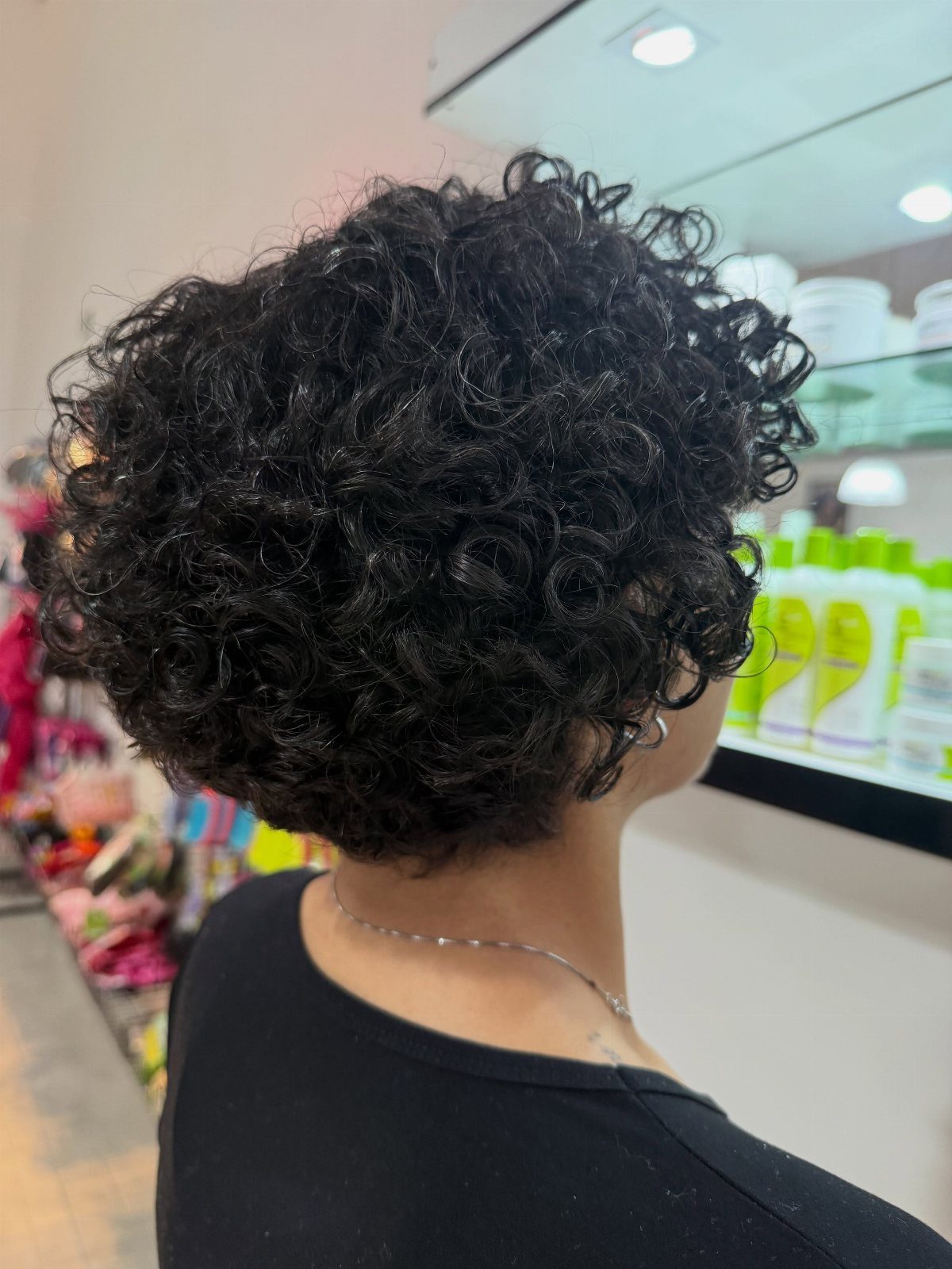 Short rounded curly bob with dense natural black curls