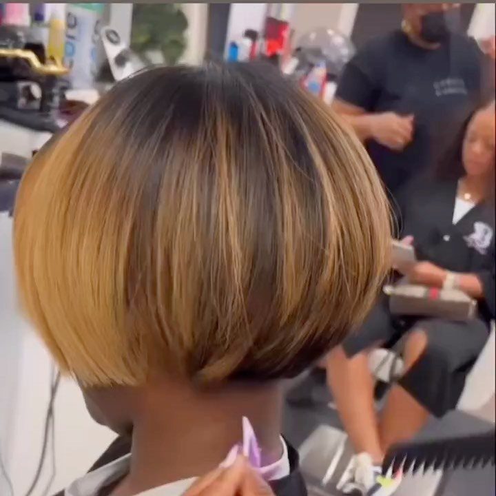 Rounded highlighted bob curves inward around the back of the head in a salon