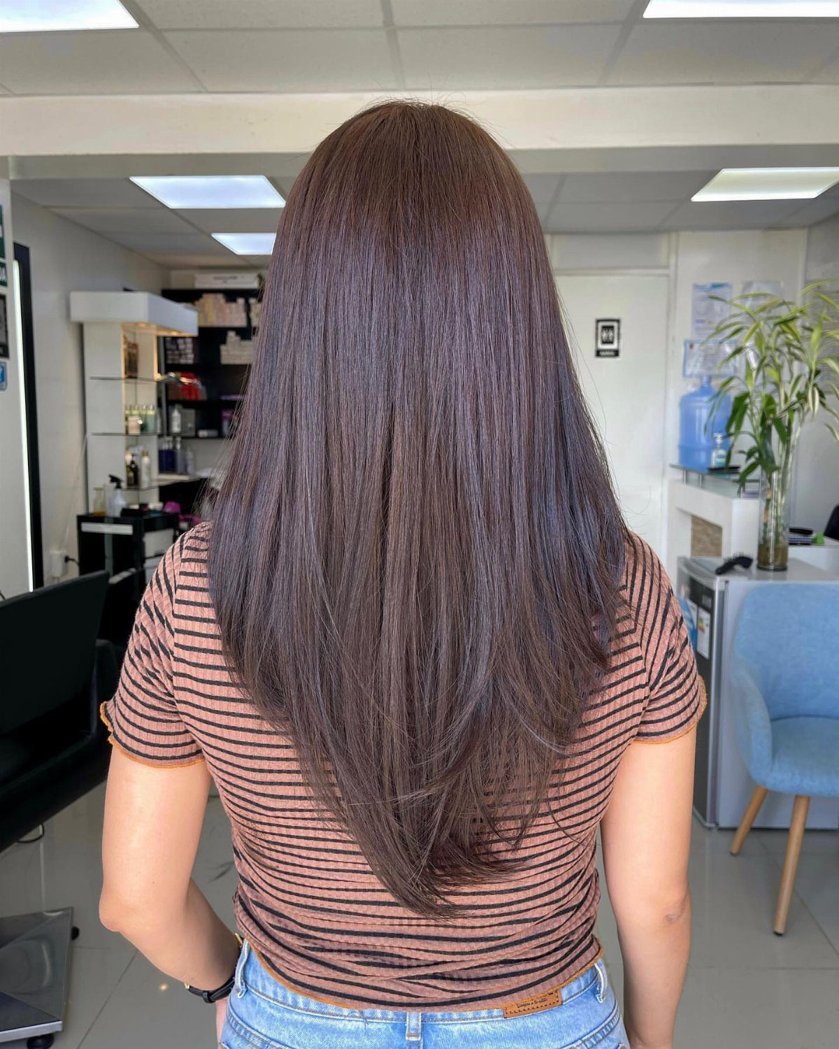 Long dark hair falls into a pointed V shape down the back