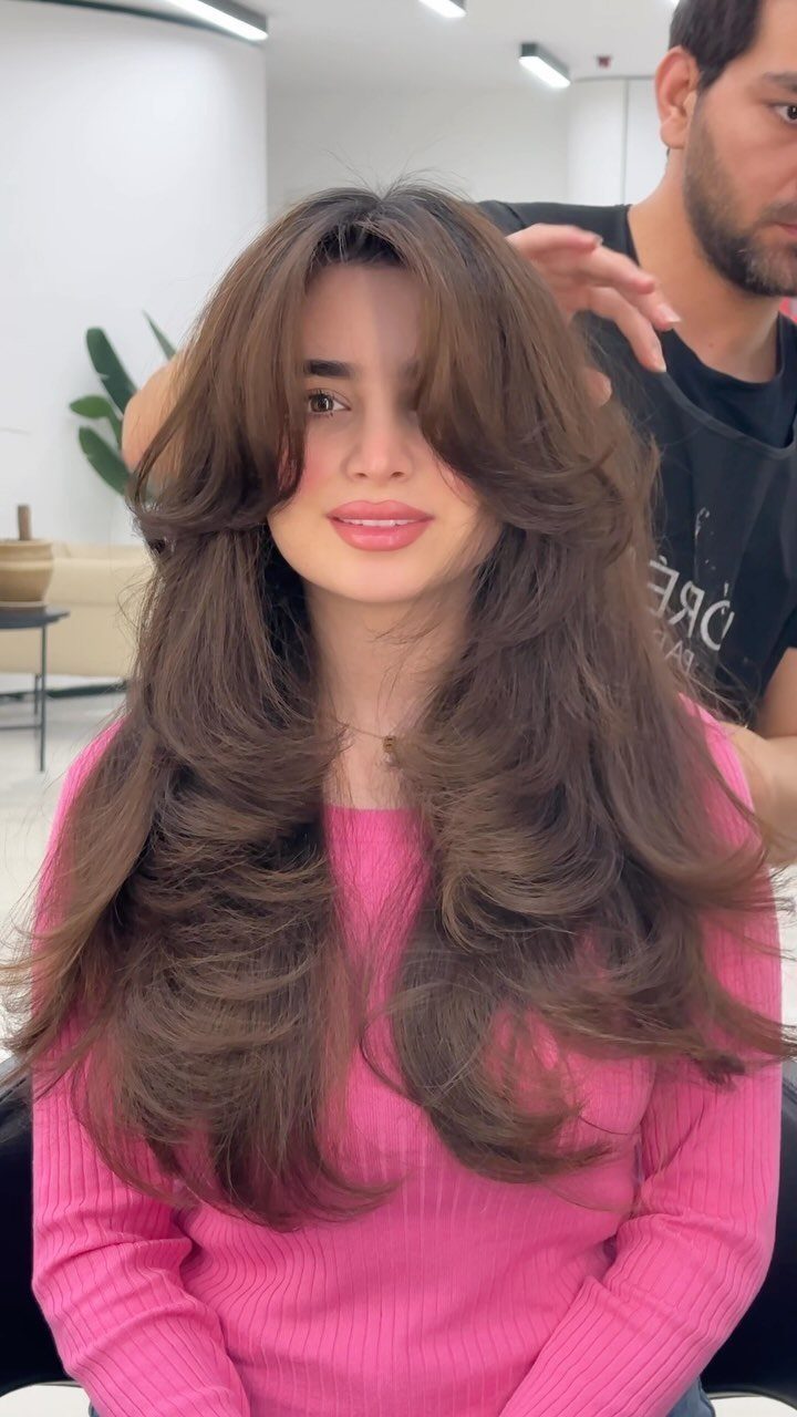 Woman showing long brown butterfly cut layers with flippy face-framing ends