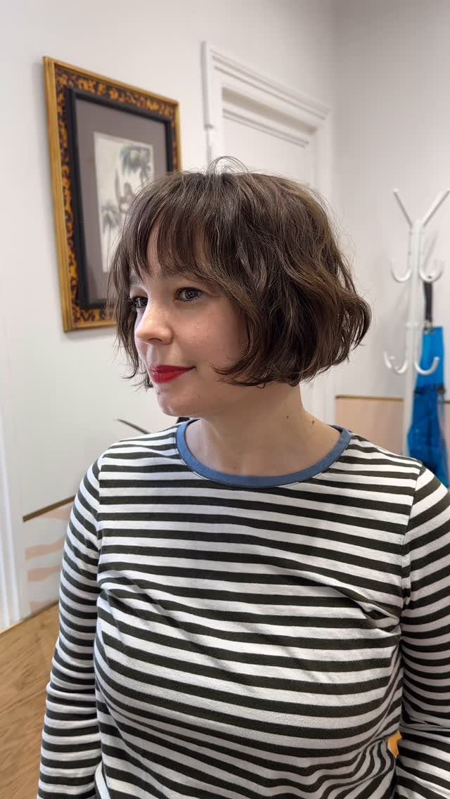 Woman showing a textured jaw-length brown bob with short bangs