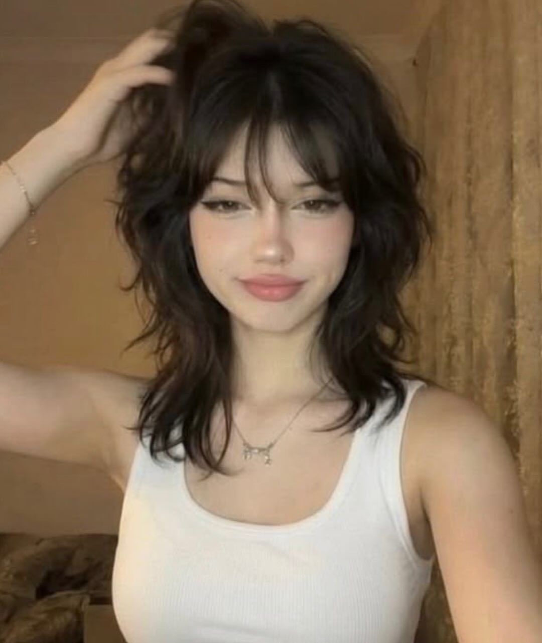Dark layered wolf cut with wispy bangs and shoulder-length pieces