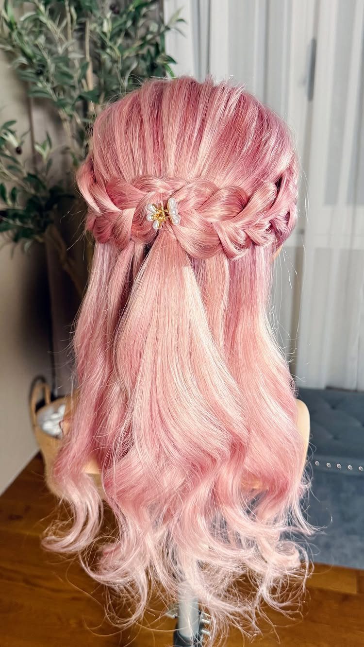 Pink hair with a braided top section and loose curled lengths