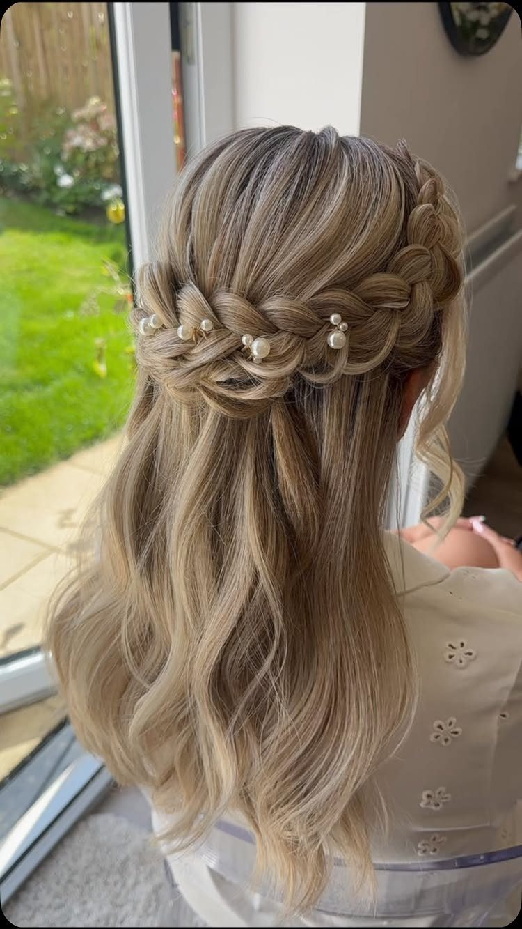 Balayage hair in a chunky half-up braid with pearl pins and loose waves