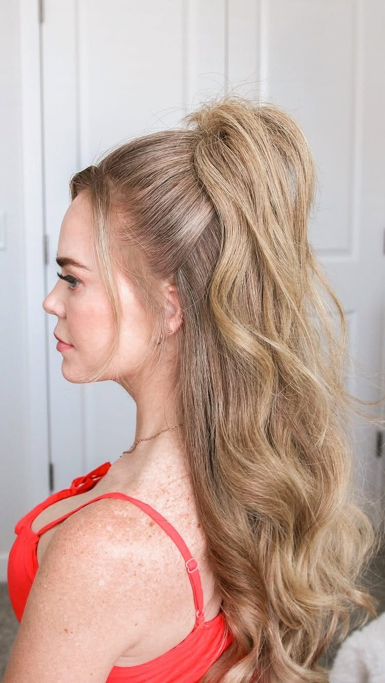 Blonde woman with a high half-up ponytail and long cascading curls