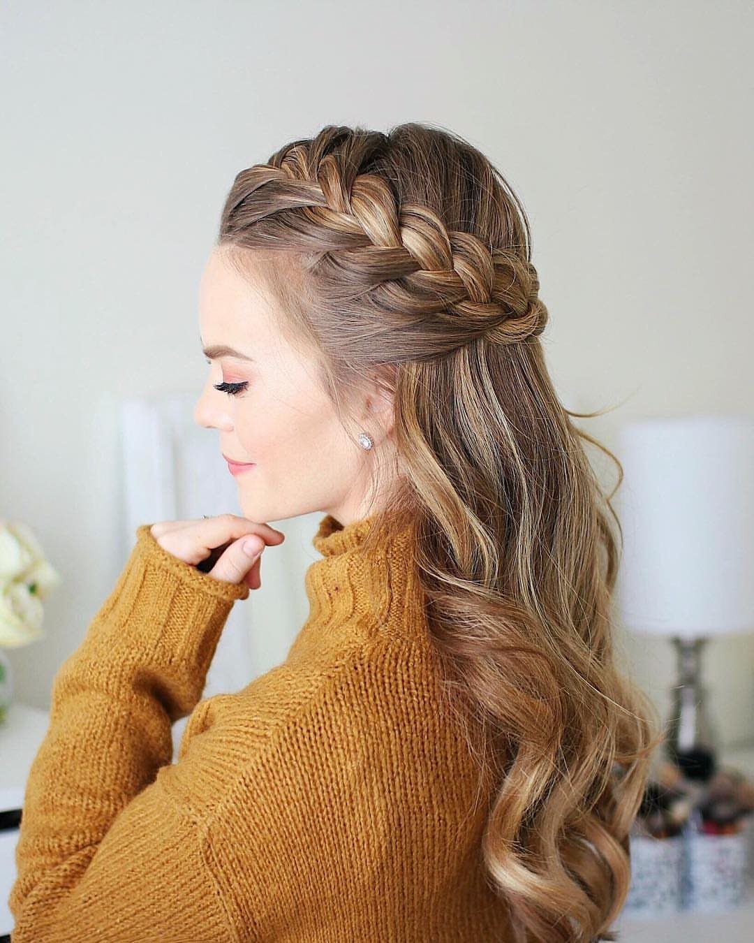 Crown braid wraps around long brown hair above loose curls