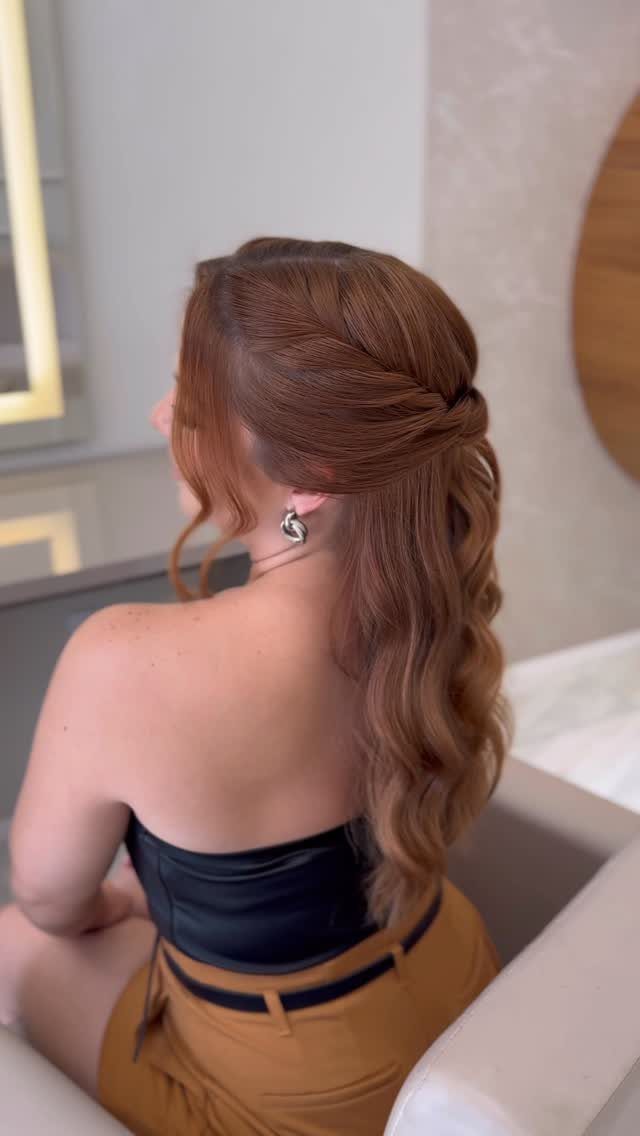 Twisted auburn hair falls in loose waves down the woman's back