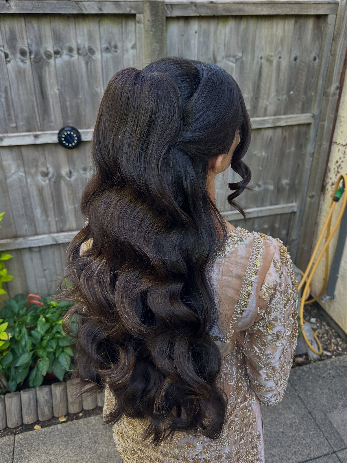 Half-up dark hair with a voluminous crown and long, flowing curls