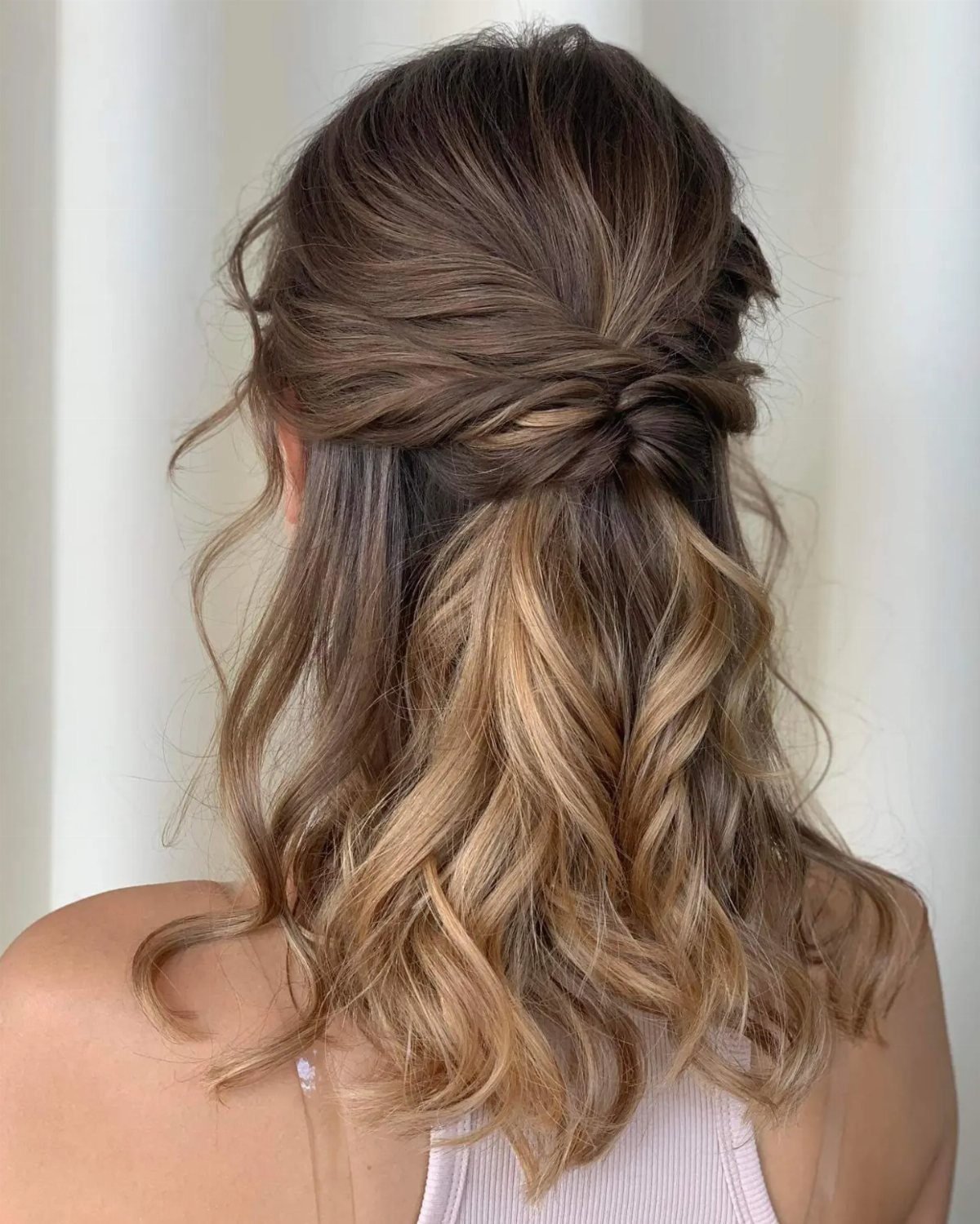 Half-up highlighted hair styled in loose twists over shoulder-length curls