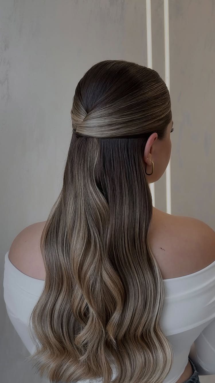 Long wavy hair swept back smoothly at the crown above loose curls