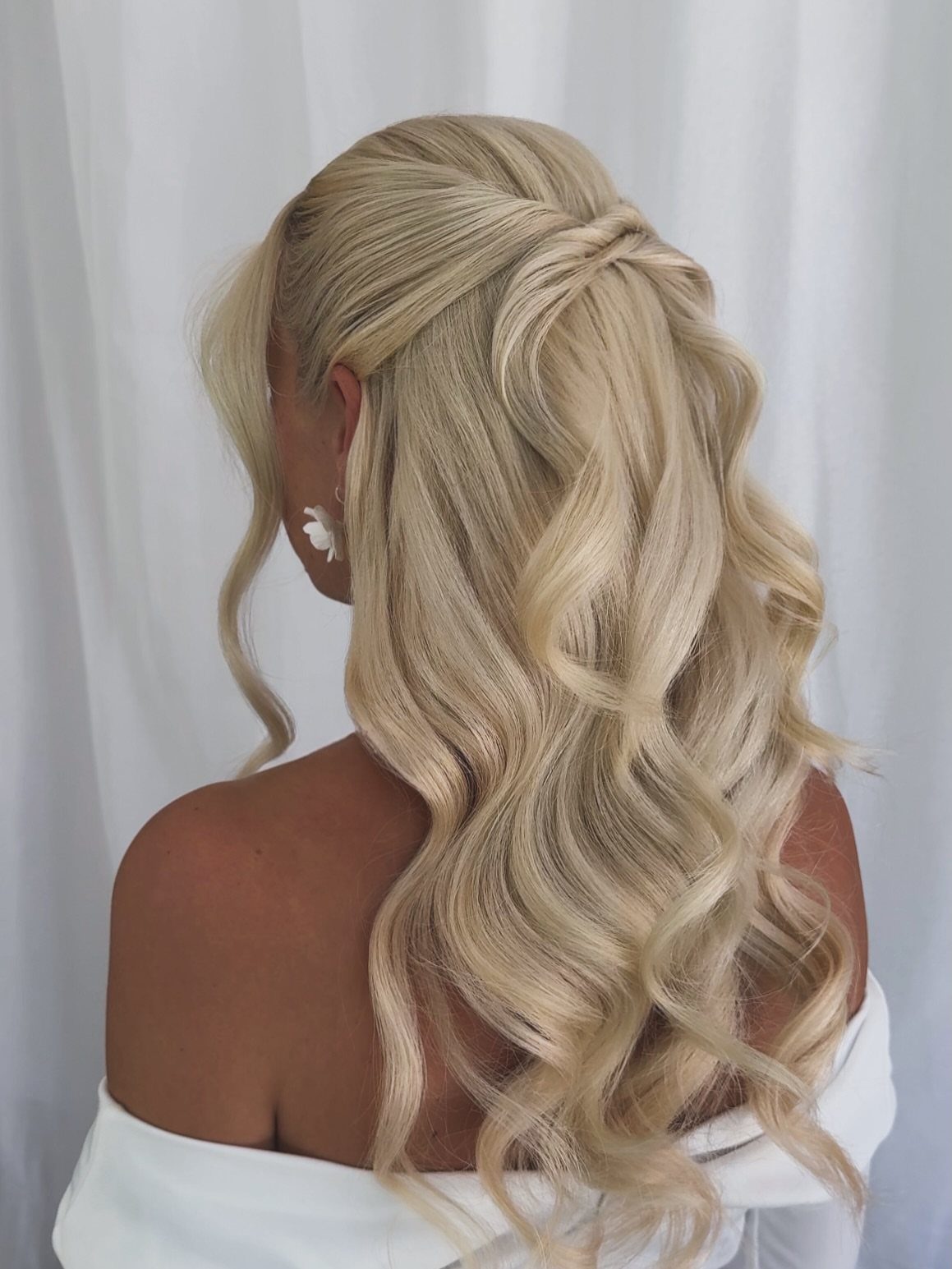 Blonde half-up hairstyle with pinned twists and long cascading curls