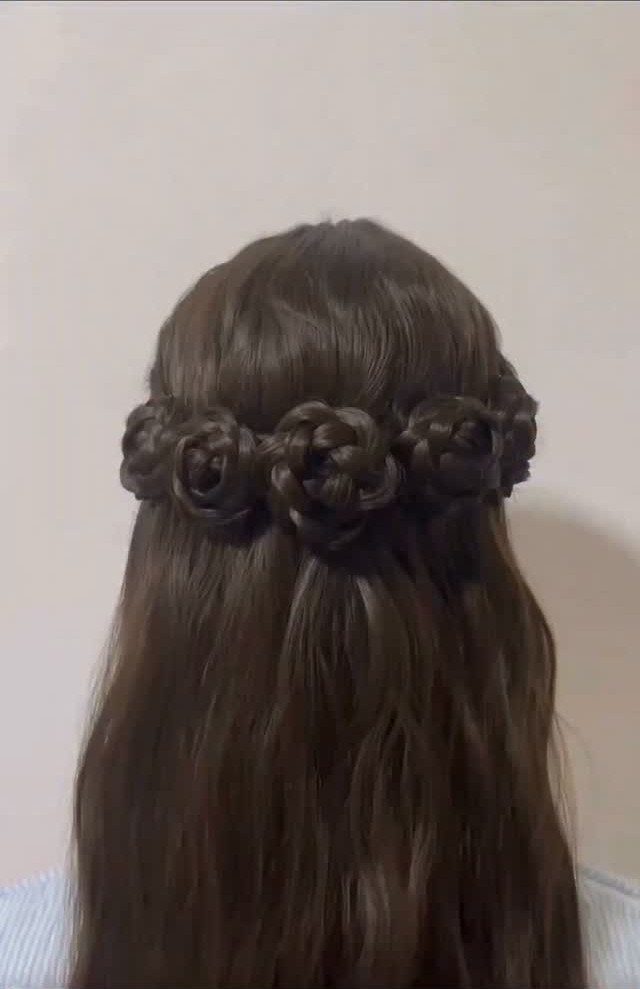 Long dark hair with braided rose shapes arranged across the back