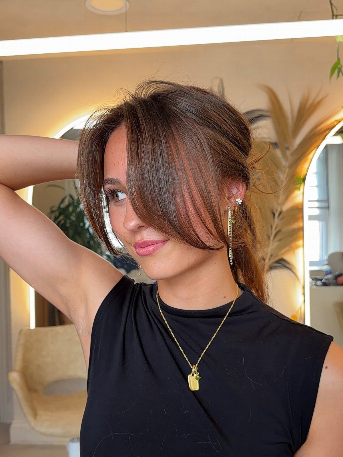 Woman showing a half-up hairstyle with long curtain bangs framing her face