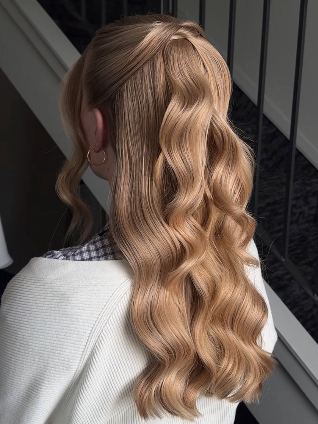 Blonde wavy half-up hairstyle with loose strands framing the face