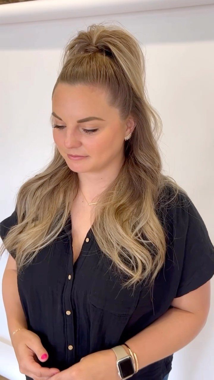 Woman wearing a high half-up ponytail with long, loose blonde waves