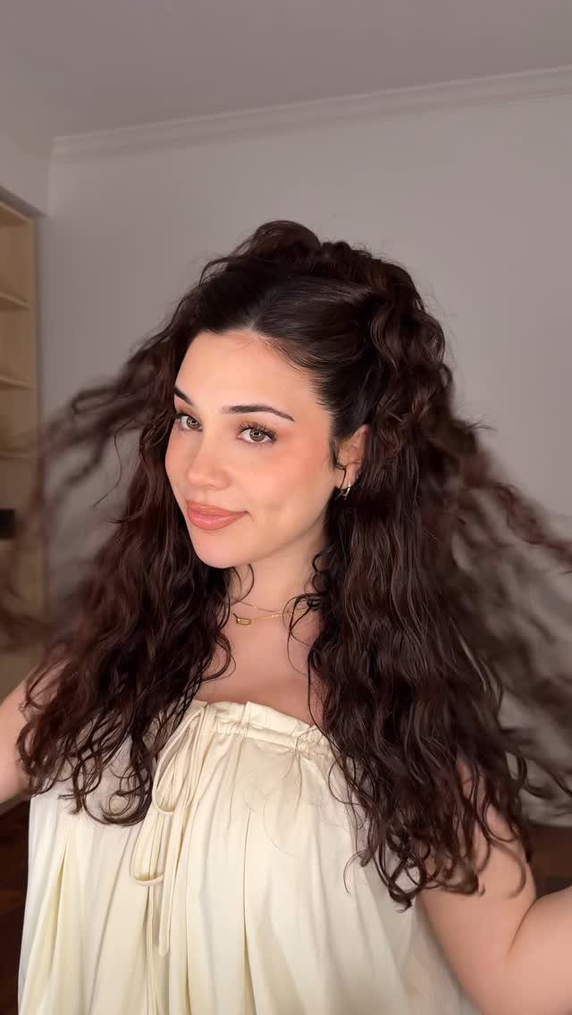 Woman wearing long, tousled waves in a voluminous half-up hairstyle